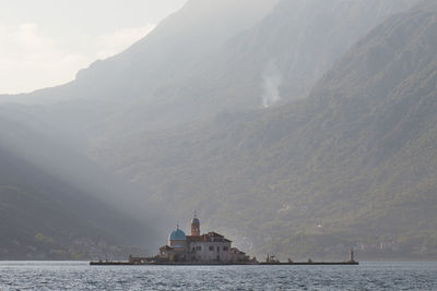 Scenic view of island by buildings against sky