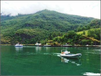 Boats sailing in lake against sky