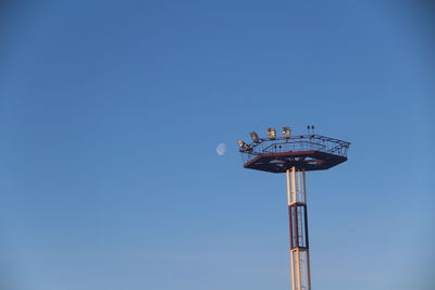Low angle view of rollercoaster against clear blue sky