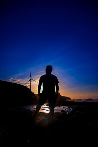 Rear view of silhouette man standing against sky during sunset