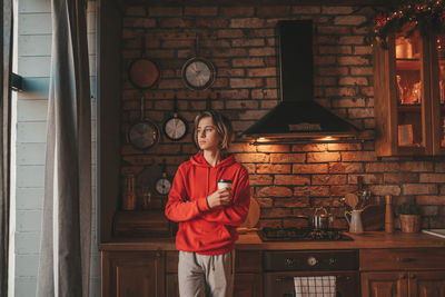 Portrait of candid authentic smiling boy teenager reading book on distance studying at home xmas