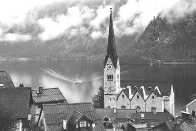 View of church by lake against sky