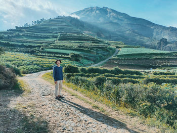 Man standing on field against mountains