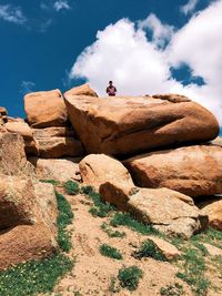 Low angle view of horse standing on rock against sky