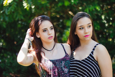 Beautiful young women standing against trees