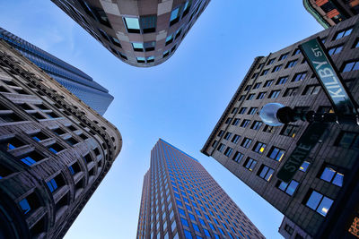 Directly below shot of modern buildings against clear sky