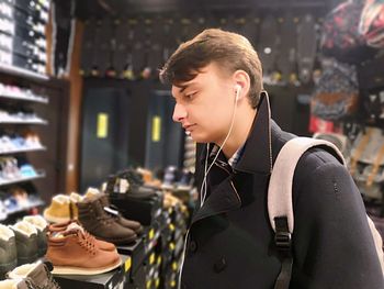 Portrait of young man looking at store