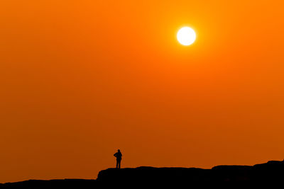 Sunset and orange gold scene and silhouette small tourist on mountain foreground at sam phan bok