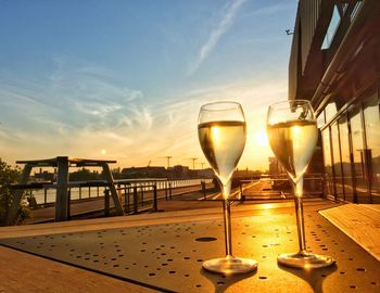 Wine glasses on table at sunset