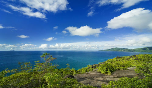 Panoramic view from the mountain, covered with greenery, to the turquoise sea and distant islands.