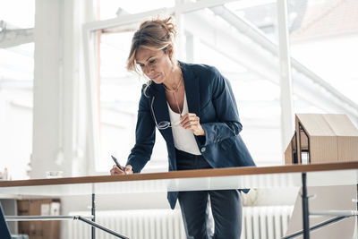 Architect holding eyeglasses working in office