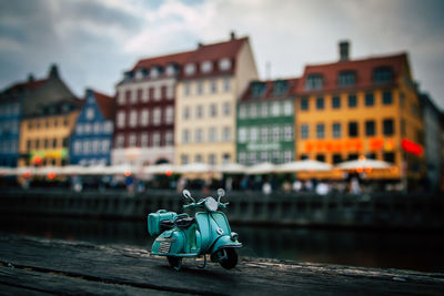 Toy scooter against buildings in city