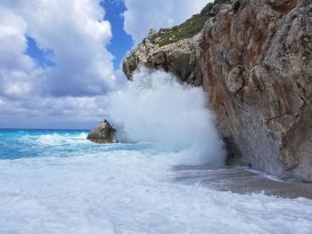 Scenic view of rock formation in sea against sky