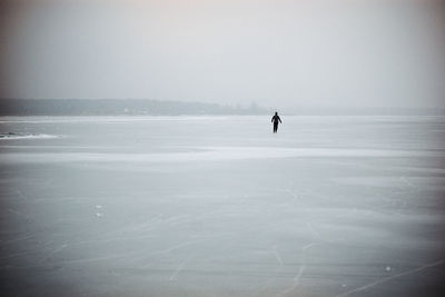 Silhouette man on beach against sky