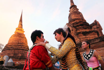 Tourists at temple against building