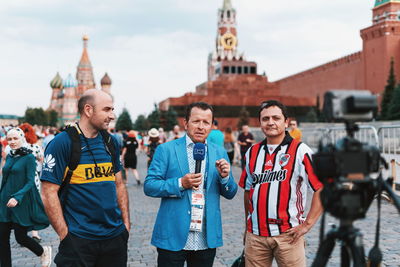 Portrait of friends standing against buildings