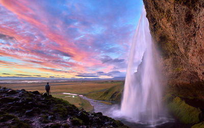 Scenic view of waterfall against sky