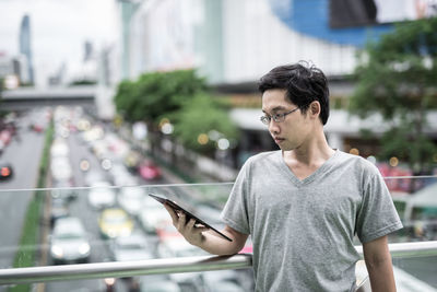 Young man using mobile phone in city