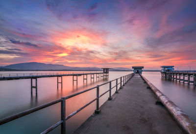 Pier over sea against sky during sunset