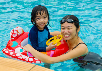 Portrait of happy mother and daughter in swimming pool