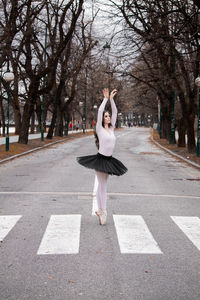 Side view of ballerina dancing on road