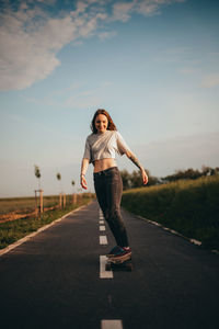 Full length of woman skating on road