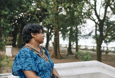 Portrait of a pensive looking indian woman standing near ledge of a garden-house, near ganges