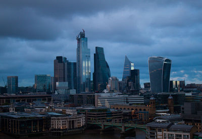 Modern buildings in city against cloudy sky