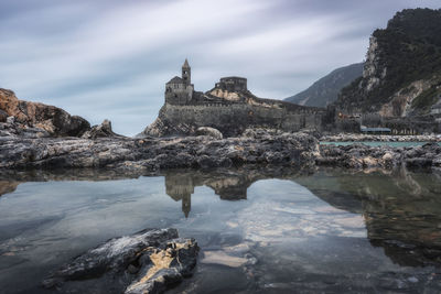 The church of san pietro in portovenere is mirrored on the island of palmaria, italy.