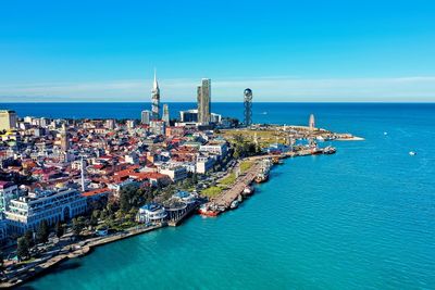 High angle view of city by sea against sky