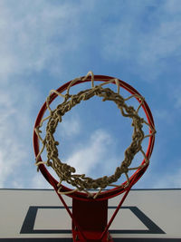 Basketball hoop with net on an outdoor court with sky and clouds background