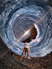 Woman standing in water at night