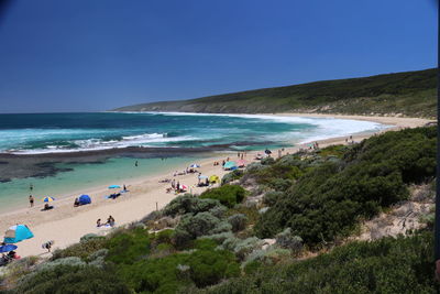 Scenic view of beach against clear blue sky