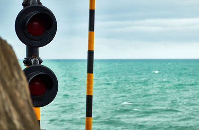 Close-up of pole on sea against sky