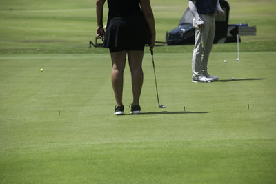 A back shot of an active woman playing golf in mexico