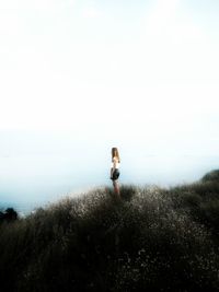 Man standing on beach against clear sky