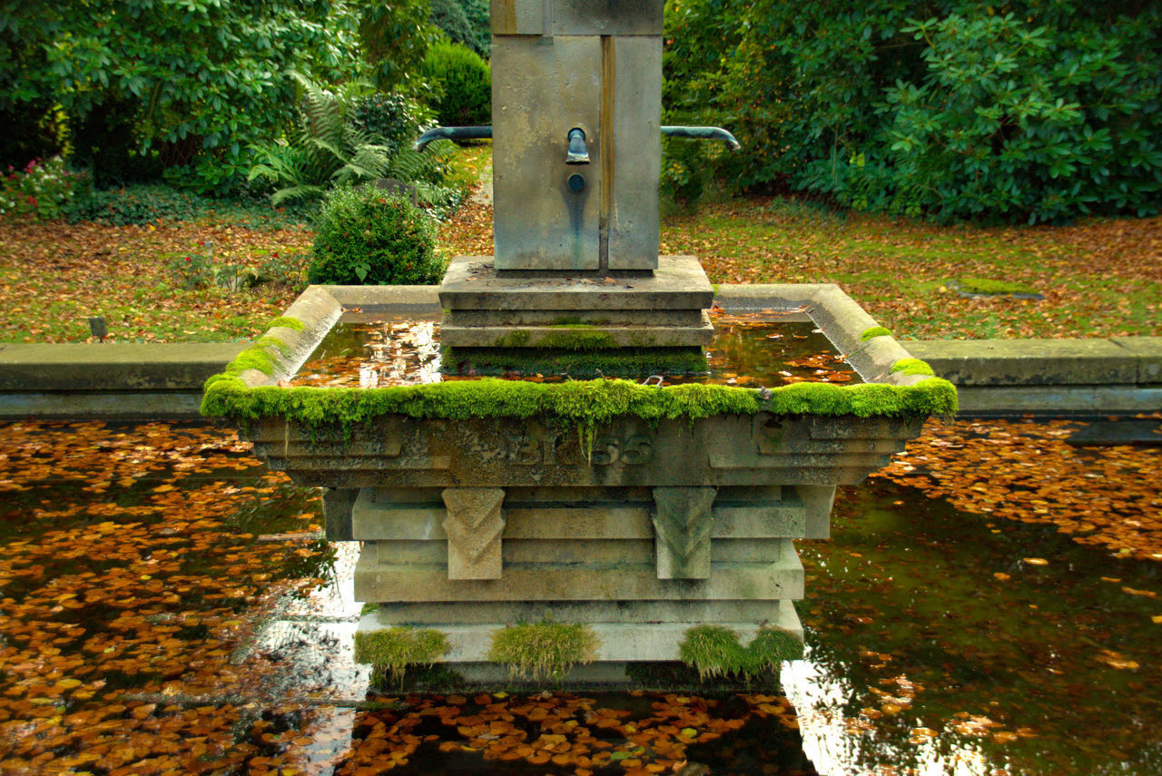 STONE STRUCTURE IN PARK BY LAKE IN FOREGROUND