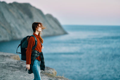 Woman looking at sea against sky