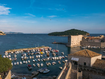 High angle view of cityscape by sea against sky