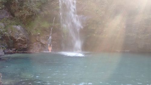 Scenic view of waterfall against sky