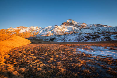 Scenic view of snowcapped mountains against clear blue sky