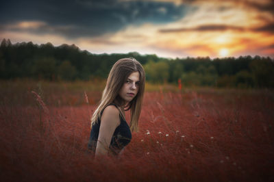 Portrait of woman on field against sky during sunset