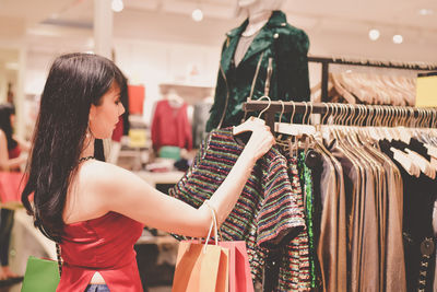 Young woman buying clothes in shopping mall