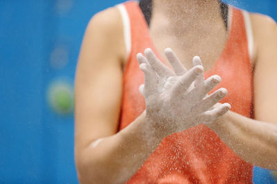 Midsection of woman with hands clasped by sand