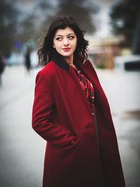 Woman wearing red overcoat on snow covered field