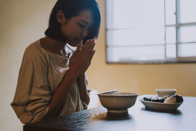 Beautiful woman eating food sitting at home