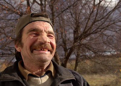 Portrait of man with bare tree in winter