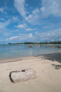 Scenic view of beach against cloudy sky