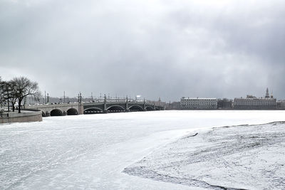 Bridge over snow covered city against sky