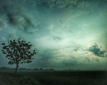 Scenic view of field against storm clouds